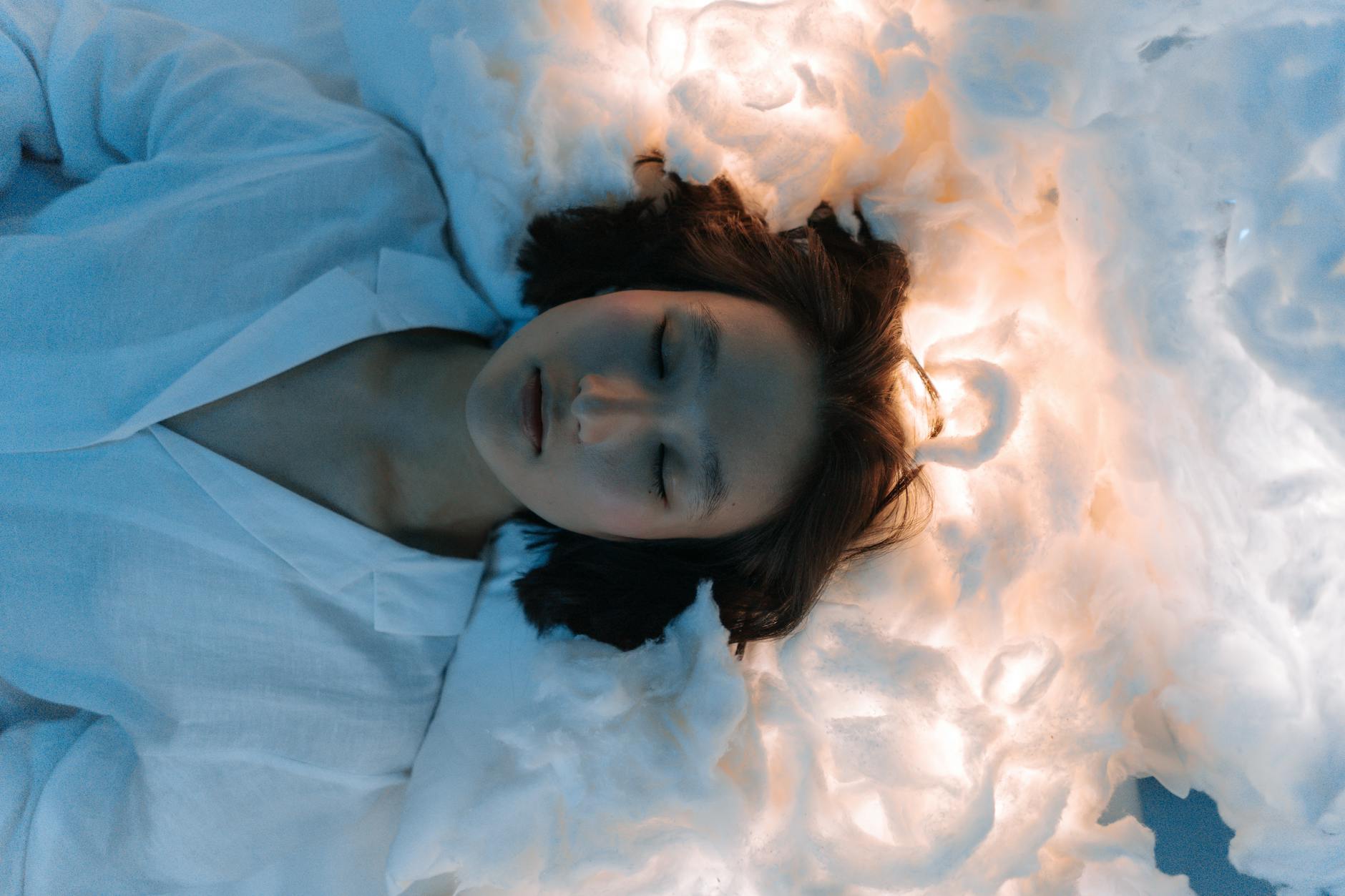 woman lying on white cotton