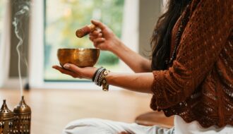 woman in brown knit sweater holding brown ceramic cup